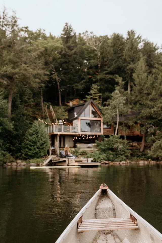 Paddling toward the treehouse cottage from a canoe on calm Three Mile Lake.